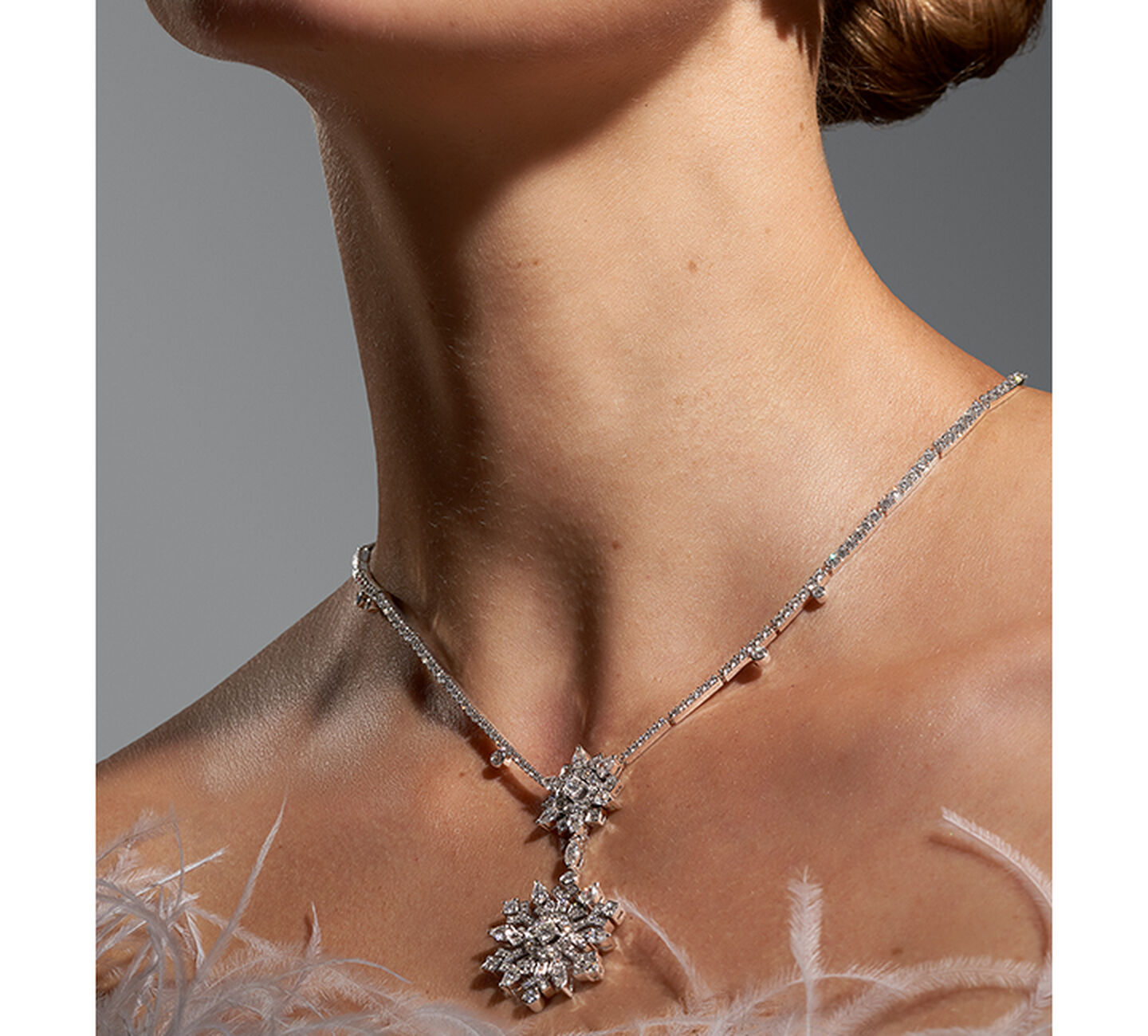 A pair of Snowflake shaped diamond earrings on model