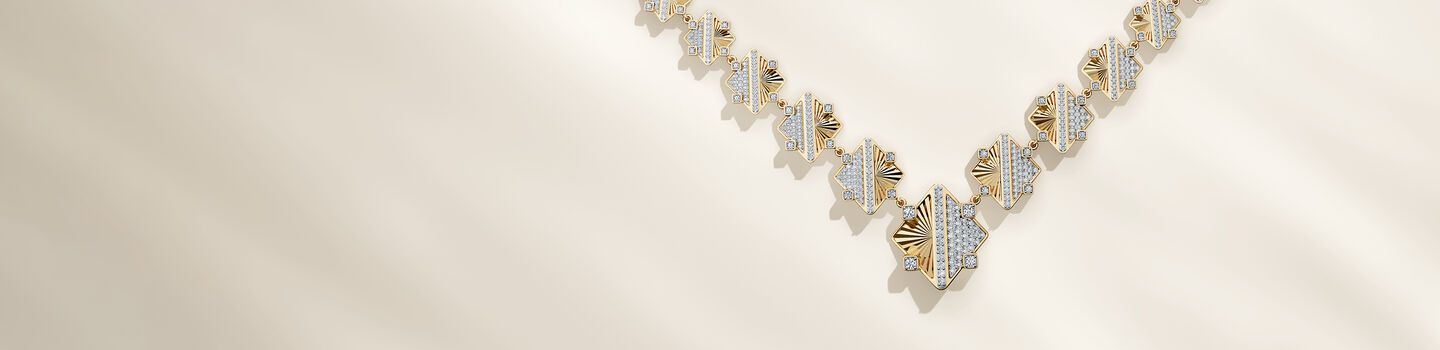 Birks Muse Exceptional gold and diamond necklace on a beige background.
