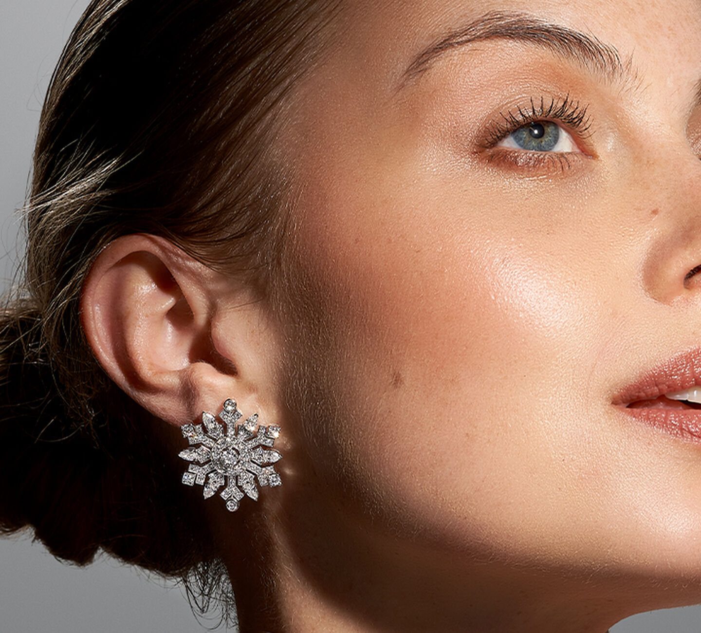 A pair of Snowflake shaped diamond earrings on model