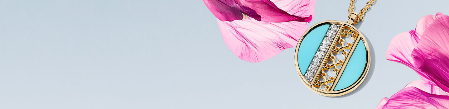 Birks Dare to Dream turquiose medallion on a light sky blue and pink flower background.