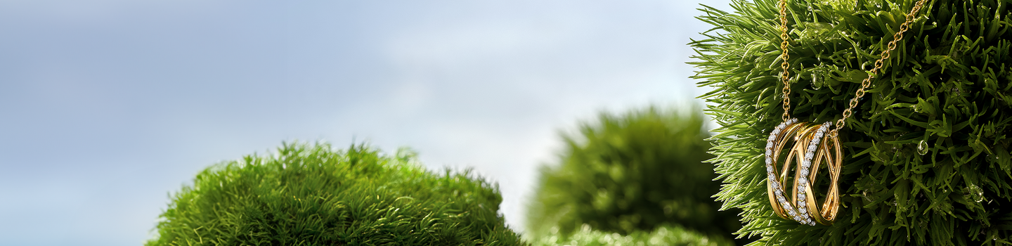 Birks Rosee du Matin diamond and gold necklace on a green grass background