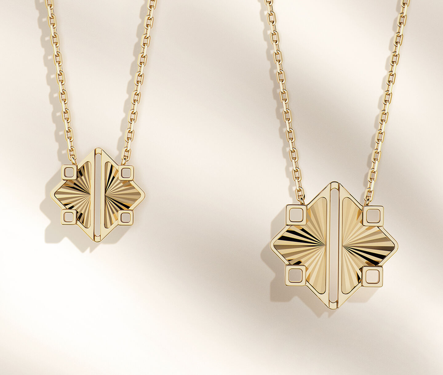 Deux colliers en or jaune Birks Muse sur un fond beige.