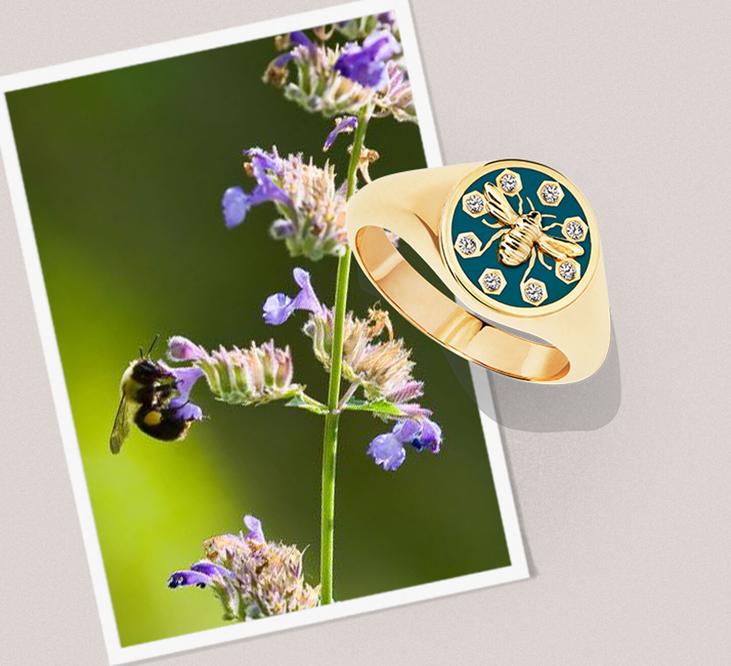 A gold ring with diamonds and a gold bee sits on a photo of a bee on a purple flower.