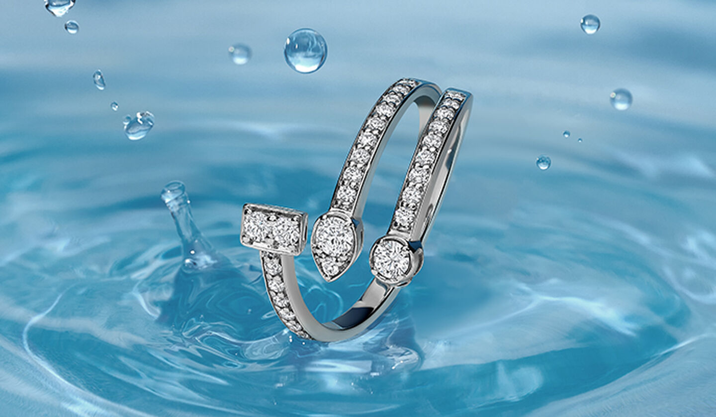 Birks Splash white gold 3 row diamond ring on a blue with water splash drop on the background.