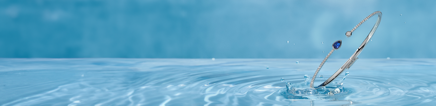 Birks Splash Sapphire diamond bangle on a ice blue water background.